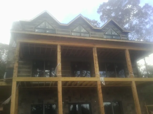 Dormers and porch framing on a large log home under construction — Roof Coating work by our crew in Estacada